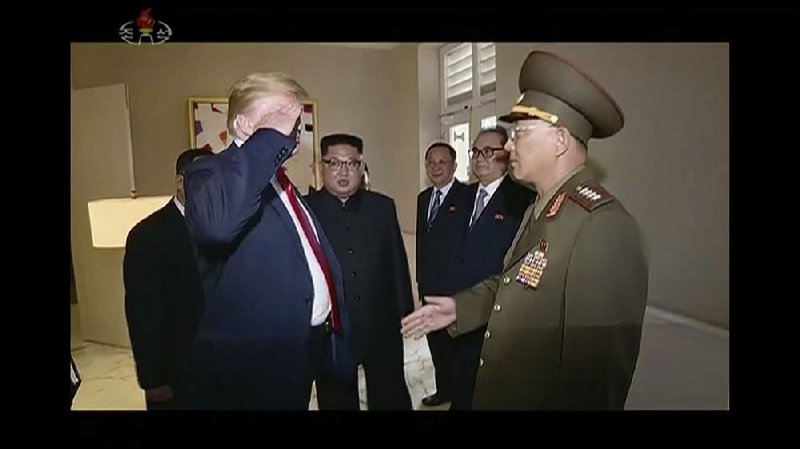 President Donald Trump salutes Gen. No Kwang Chol, minister of the People’s Armed Forces of North Korea, as Kim Jong Un watches in background. Trump had offered a handshake before No saluted, then Trump returned the salute and they finally shook hands.  