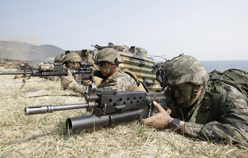 FILE - In this March 30, 2015, file photo, marines of South Korea, right, and the U.S aim their weapons near amphibious assault vehicles during U.S.-South Korea joint landing military exercises as part of the annual joint military exercise Foal Eagle between the two countries in Pohang, South Korea. U.S. President Donald Trump promised to end "war games" with South Korea, calling them provocative, after meeting North Korean leader Kim Jong Un on June 12, 2018. His announcement appeared to catch both South Korea and the Pentagon by surprise. (AP Photo/Lee Jin-man, File)