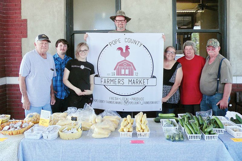 Several vendors were set up for the Tuesday-evening Pope County Farmers Market on June 5 at the Russellville Depot. They include, from left, James Mashek, Treylan Swaim, Andi Kuroki, Tom Green, Lisa Alverson, Rhonda Holland and Ric Holland. The Pope County Farmers Market will host Veggie Fest on Saturday.