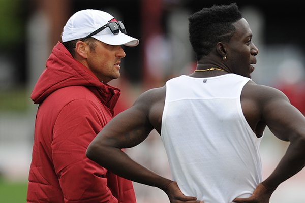 Arkansas senior Clive Pullen (right) speaks Saturday, April 22, 2017, to events coach Travis Geopfert while competing in the triple jump during the John McDonnell Invitational at John McDonnell Field in Fayetteville.