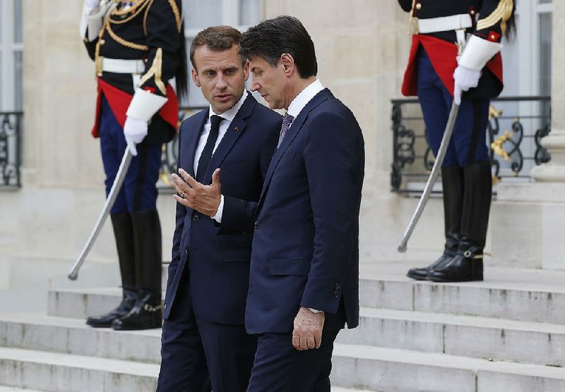 French President Emmanuel Macron (left) talks with Italian Premier Giuseppe Conte as they leave after their meeting Friday at Elysee Palace in Paris.  