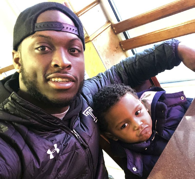 Former Temple running back David Hood takes a selfie with his son, David IV, on Feb. 10 in Mays Landing, N.J. Hood, who was Temple’s leading rusher last season, was one of four Owls players parenting young children in 2017.  
