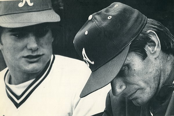 Arkansas coach Norm DeBriyn, right, looks toward the ground while catcher Ronn Reynolds watches during a College World Series game against Cal State Fullerton on Friday, June 8, 1979, in Omaha, Neb. 