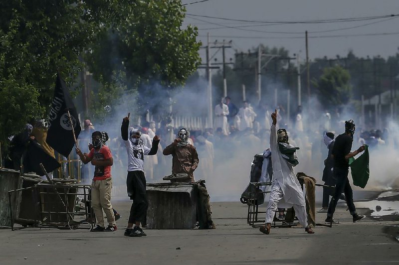 Kashmiri demonstrators clash with Indian security officers Saturday during a protest against Indian rule. At least one person was killed and at least two dozen wounded in the violence shortly after prayers on the Eid al-Fitr holiday marking the end of the Muslim holy month of Ramadan. 