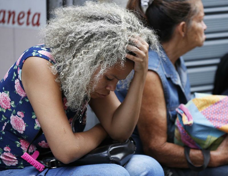 Women wait outside police headquarters in Caracas, Venezuela, after Saturday’s stampede at the Los Cotorros club. 