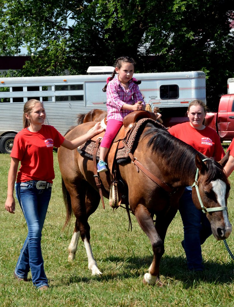 Hunter McFerrin/Herald-Leader Rodeo of the Ozarks "Rounders" supervise Lucia Manahl as she finishes up with her horse ride.