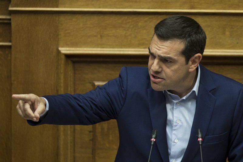 Greek Prime Minister Alexis Tsipras speaks to lawmakers during a parliamentary session , in Athens, on Saturday, June 16, 2018. Greek lawmakers on Saturday debated for the third and final day a no-confidence motion against the government over a deal to end a decades-old dispute with neighboring Macedonia over the latter's name. (AP Photo/Petros Giannakouris)