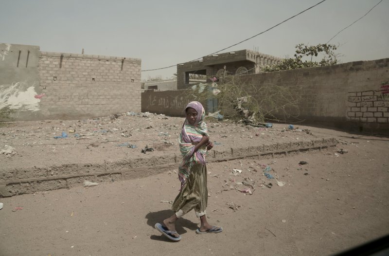 In this Feb. 12, 2018, photo, a girl walks alone on a street in al-Khoukha, Yemen. Since the Saudi-led coalition began its bombing campaign against the rebels in 2015, the U.N. estimates that some 10,000 civilians have been killed. Millions need humanitarian assistance and have been forced to flee their homes. (AP Photo/Nariman El-Mofty)