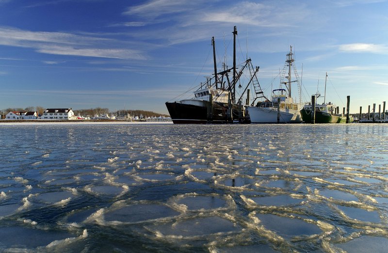 Surrounded by ice, commercial fishing boats are docked in their slips after more than a week's worth of frigid weather froze the harbor in Lake Montauk in Montauk, N.Y., on Sunday, Jan. 7, 2018. Only a few commercial boats remain in Montauk harbor during the winter months fishing for species such as porgy, tilefish, monkfish and black sea bass. (AP Photo/Julie Jacobson)