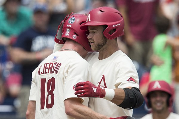 Heston Kjerstad (left), Arkansas left fielder, congratulates Luke Bonfield, Arkansas designeted hitter, after Bonfield's homer brought Kjerstad in to score in the 5th inning vs Texas Sunday, June 17, 2018, during game three of the NCAA Men's College World Series at TD Ameritrade Park in Omaha.