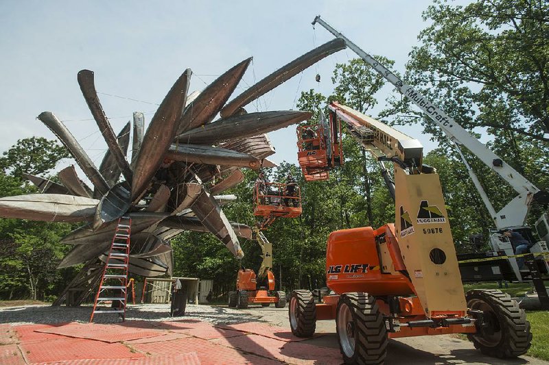 A crew installs the sculpture Monochrome II by Nancy Rubins on June 7 on the North Forest Trail at Crystal Bridges Museum of American Art in Bentonville. The sculpture is fabricated from aluminum canoes and jon boats. 