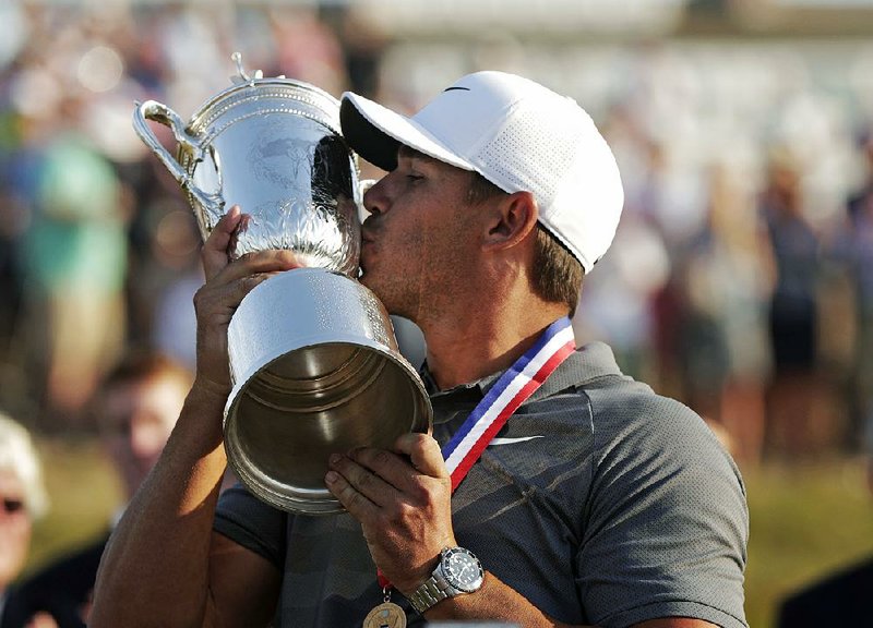 Brooks Koepka kisses the trophy after winning the U.S. Open on Sunday in Southampton, N.Y. Koepka closed with a 2-under 68 to become the first repeat champion in 29 years. 