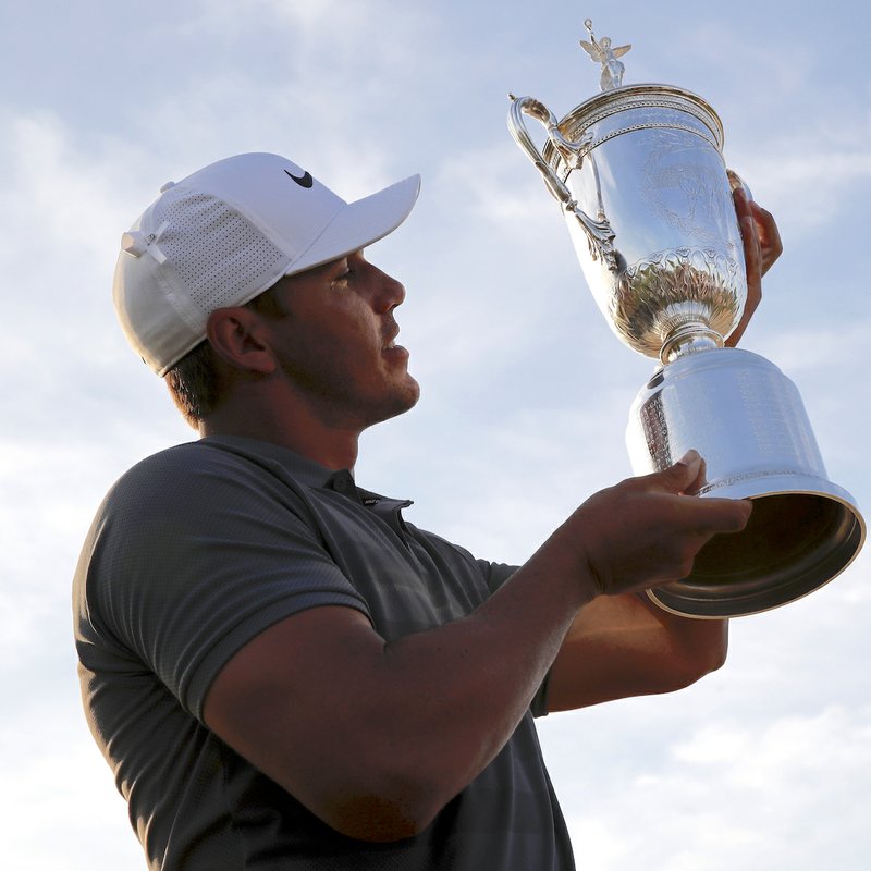 Brooks Koepka holds up the Golf Champion Trophy after winning the U.S. Open Golf Championship, Sunday, June 17, 2018, in Southampton, N.Y. (AP Photo/Carolyn Kaster) 