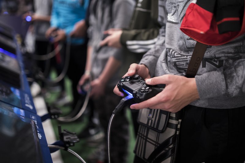 FILE - In this Friday, Nov. 3, 2017 file photo, a man plays a game at the Paris Games Week in Paris. The World Health Organization says that compulsively playing video games now qualifies as a new mental health condition, in a move that some critics warn may risk stigmatizing its young players. (AP Photo/Kamil Zihnioglu, File)