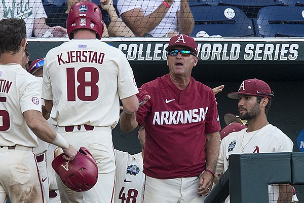 Arkansas coach Dave Van Horn greets Heston Kjerstad (18) after he scored a run during the sixth inning of a College World Series game against Texas on Sunday, June 17, 2018, in Omaha, Neb.
