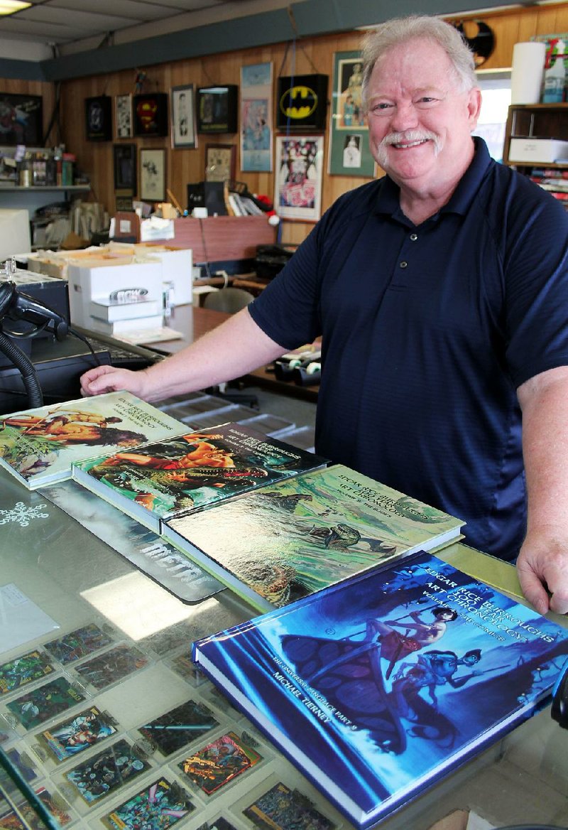 Michael Tierney, owner of Collector’s Edition Comics in North Little Rock and The Comic Book Store in Little Rock, shows off his four-volume Edgar Rice Burroughs 100 Year Art Chronology. 