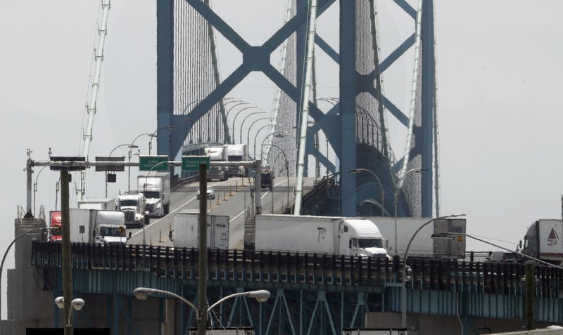 In this Tuesday, June 12, 2018, photo, trucks cross the Ambassador Bridge from Windsor, Ontario into Detroit. In nearly a quarter-century since NAFTA was approved, a complex chain of automotive parts makers has sprung up on both sides of the U.S.-Canada border. About 7,400 trucks cross the bridge between Detroit and Windsor every day, many laden with auto parts. (AP Photo/Paul Sancya)