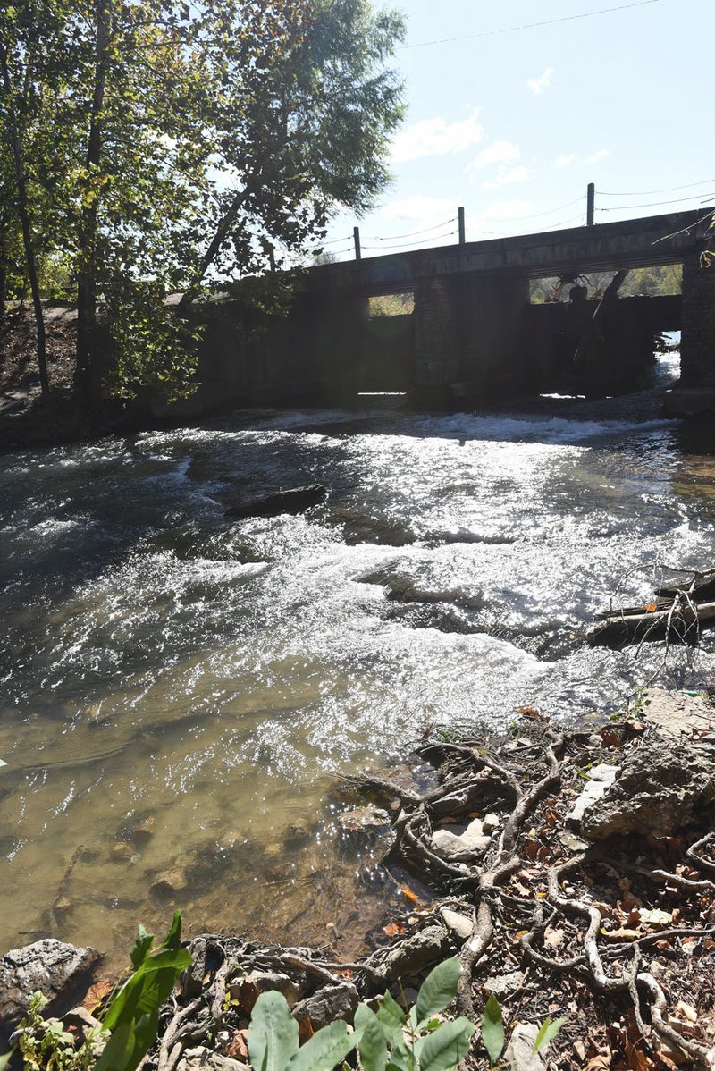 File Photo/NWA Democrat-Gazette/FLIP PUTTHOFF Little Sugar Creek emerges Oct. 24 from a spillway at the Lake Bella Vista dam.