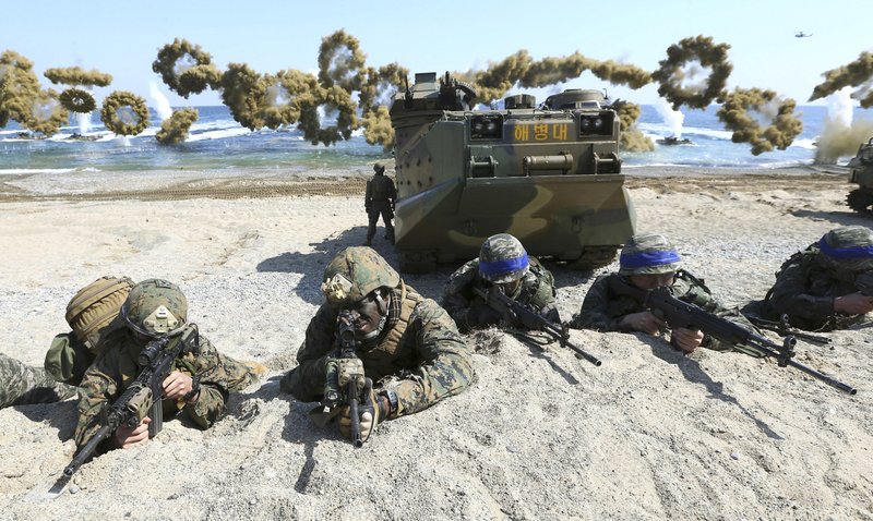 FILE - In this March 12, 2016, file photo, Marines of the U.S., left, and South Korea wearing blue headbands on their helmets, take positions after landing on a beach during the joint military combined amphibious exercise, called Ssangyong, part of the Key Resolve and Foal Eagle military exercises, in Pohang, South Korea.  (Kim Jun-bum/Yonhap via AP, File)