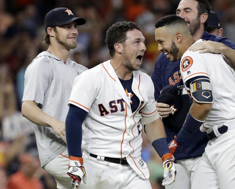 Houston Astros' Alex Bregman, center, celebrates with teammates after hitting a game-winning double to score two runs against the Tampa Bay Rays during the ninth inning of a baseball game Monday, June 18, 2018, in Houston. The Astros won 5-4. (AP Photo/David J. Phillip)