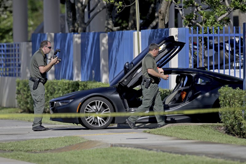 Investigators surround a vehicle after rapper XXXTentacion was shot on Monday, June 18, 2018, in Deerfield Beach, Fla. The Broward Sheriff's Office says the 20-year-old rising star was pronounced dead Monday evening at a Fort Lauderdale-area hospital. (John McCall/South Florida Sun-Sentinel via AP)

