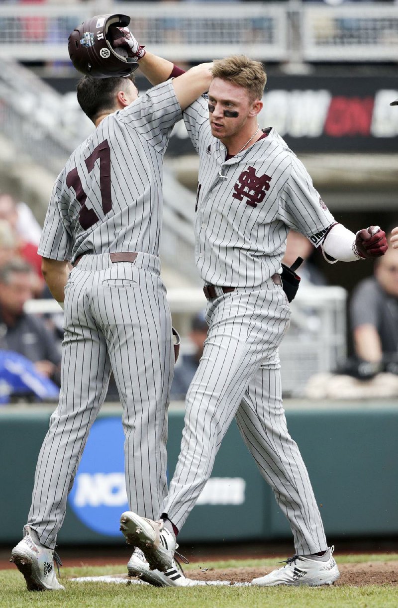 Mississippi State designated hitter Jordan Westburg (right) is congratulated by teammate Justin Foscue after hitting a grand slam in the Bulldogs’ 12-2 victory over North Carolina in the College World Series. Westburg also doubled and had seven RBI in the victory.