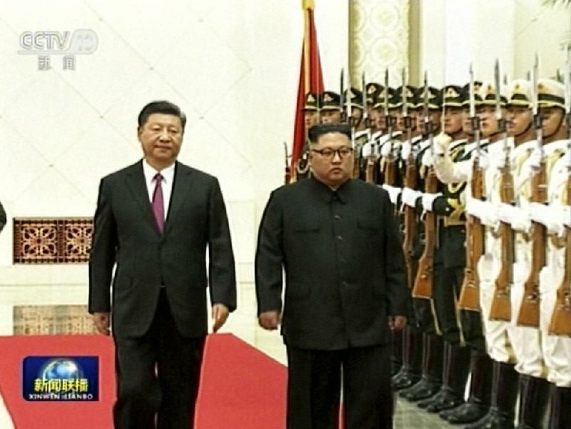 Chinese President Xi Jinping (left) walks with North Korean leader Kim Jong Un during a welcome ceremony Tuesday at the Great Hall of the People in Beijing, in this image taken from video footage run by China’s CCTV.