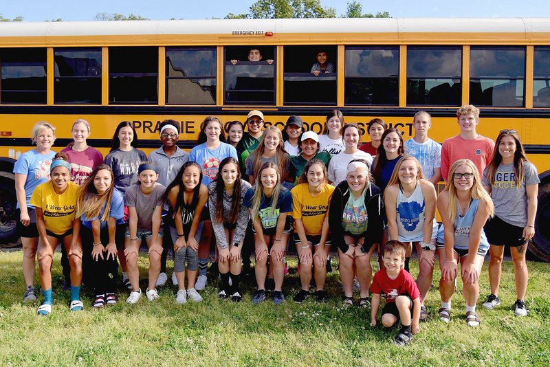 Shelley Williams Special to the Enterprise-Leader The 2018 Prairie Grove girls soccer team coached by Stephanie Mitchell (right) poses outside the high school before leaving for the State 4A girls soccer tournament in May. Two Lady Tigers were selected to the 4A All-State team.