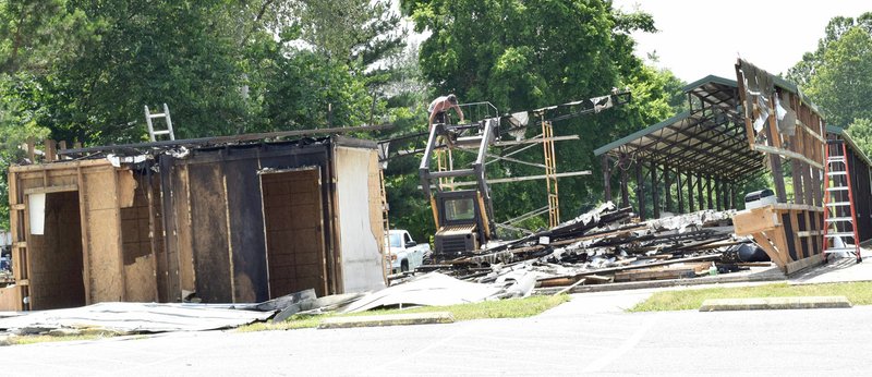 Westside Eagle Observer/MIKE ECKELS In Decatur, the last of the ceiling rafters on the burned out chicken shack at Veterans come down June 13 to make way for a new structure. A new chicken shack is expected to be completed on this site by the 2018 Decatur Barbecue August 4.