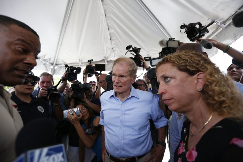 U.S. Sen. Bill Nelson (center) and U.S. Rep. Debbie Wasserman Schultz stand outside a detention center for children Tuesday in Homestead, Fla., where they were denied entry.