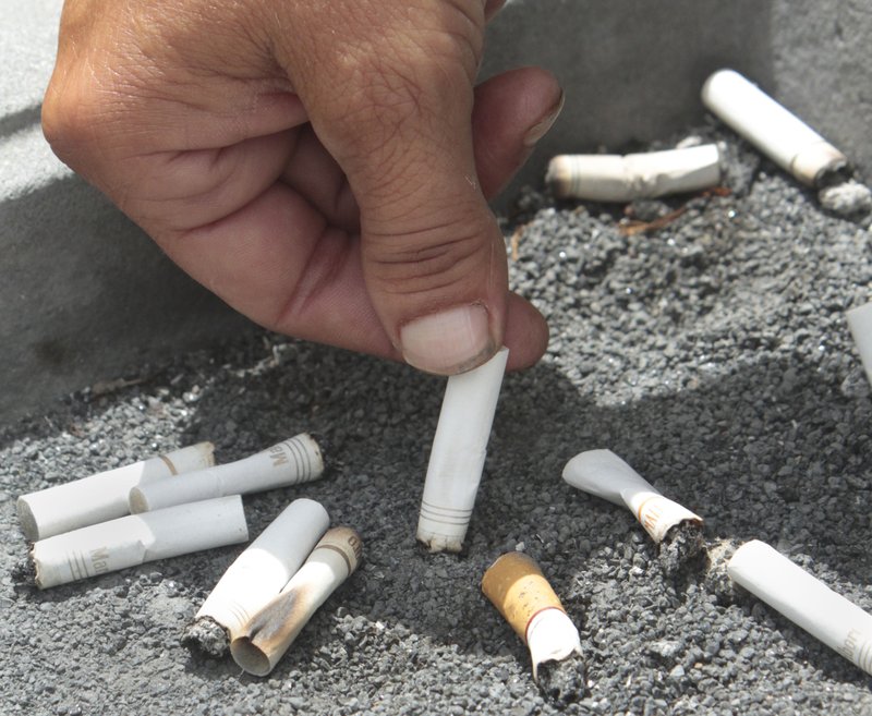 FILE - In this June 22, 2012, file photo, a smoker snuffs out a cigarette at the Capitol in Sacramento, Calif. The rate of smoking among adults in the U.S. fell to about 14 percent in 2017, according to new data released by the government Tuesday, June 19, 2018. (AP Photo/Rich Pedroncelli, File)