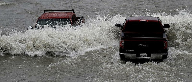 Vehicles navigate a flooded road Wednesday in Weslaco, Texas, after heavy rainfall in the area. 