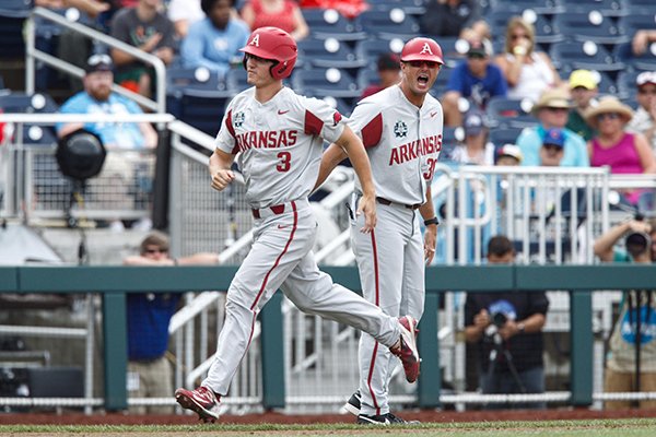 Arkansas first baseman Jared Gates (3) is congratulated by hitting coach Nate Thompson (30) after Gates hit a home run during a College World Series game against Texas Tech on Wednesday, June 20, 2018, in Omaha, Neb.