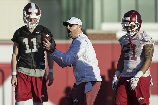 Arkansas offensive coordinator Joe Craddock (center) instructs while quarterback Daulton Hyatt (11) and running back Devwah Whaley (21) watch during practice Thursday, March 1, 2018, in Fayetteville. 