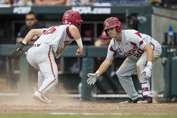 Casey Martin (left), Arkansas third baseman, celebrates with second baseman Carson Shaddy as he crosses the plate to score in the 8th inning vs Texas Tech Wednesday, June 20, 2018 in game eight of the NCAA Men's College World Series between at TD Ameritrade Park in Omaha.