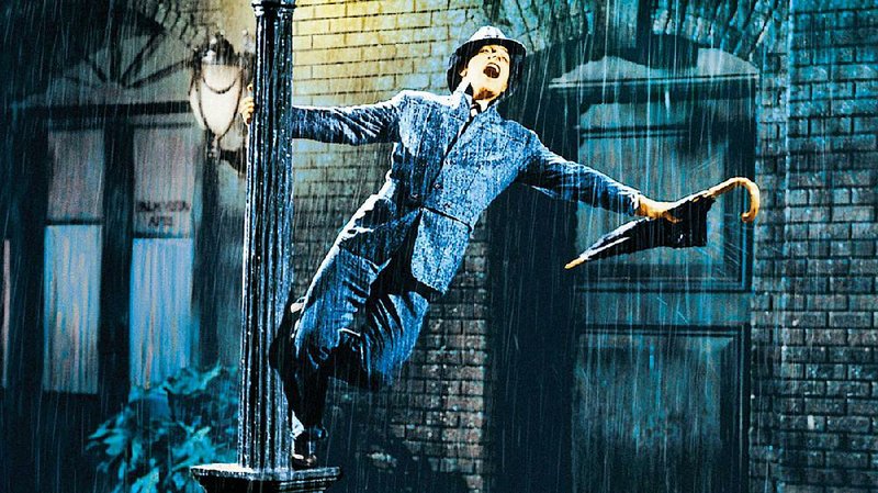 The inimitable Gene Kelly splashes around the MGM back lot in the iconic title number from Singin’ in the Rain. 
