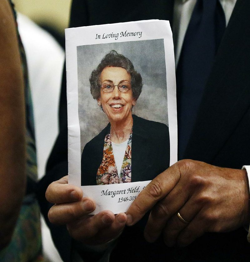 Jim Held holds a picture of his sibling Sister Margaret Held during a plea hearing Thursday for her killer in Lexington, Miss.  