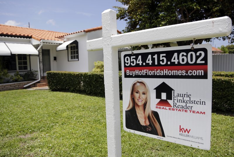 In this Wednesday, June 20, 2018 photo, a house is advertised for sale in Miami. On Thursday, June 21, Freddie Mac reports on the week&#x2019;s average U.S. mortgage rates. (AP Photo/Lynne Sladky)