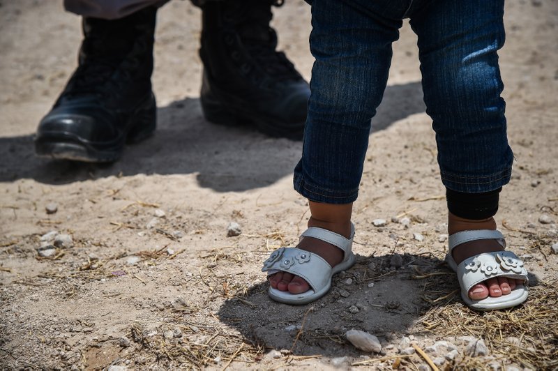 Karina Lopez's 1-year-old daughter stands next to her mother after they were detained by U.S. Border Patrol agents after crossing illegally into the United States on June 29, 2017, in McAllen, Texas. 