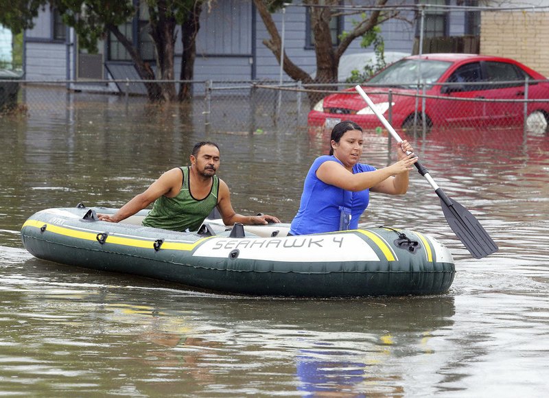 Volunteers Roxanne Arevalo and Martin Morales paddle through the flooded streets after heavy rains caused water to rise and flood whole neighborhoods on Wednesday, June 20, 2018, in Weslaco, Texas. (Joel Martinez/The Monitor via AP)