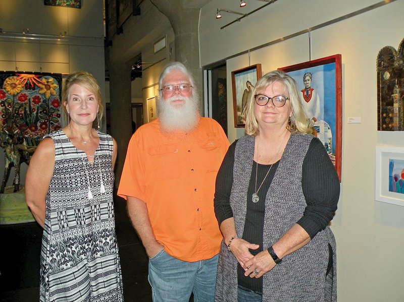 Several local artists have work in the 2018 Delta des Refusés exhibit on display in Little Rock. Among those attending the opening-night reception June 8 in the Underground Gallery of the Butler Center for Arkansas Studies are Debra Caldwell, from left, David Paul McGhee and Jo Lynne Varner.
