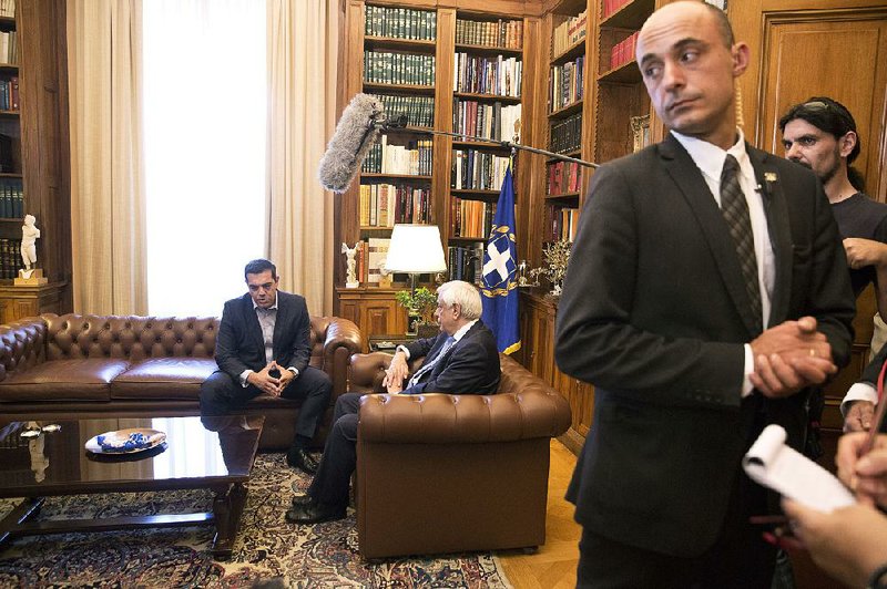 Greek Prime Minister Alexis Tsipras (left) sits down for a meeting Friday in Athens with the country’s president Prokopis Pavlopoulos. Tsipras said Friday’s deal on debt-relief measures will help Greece become “a normal country.”  AP/PETROS GIANNAKOURIS 
