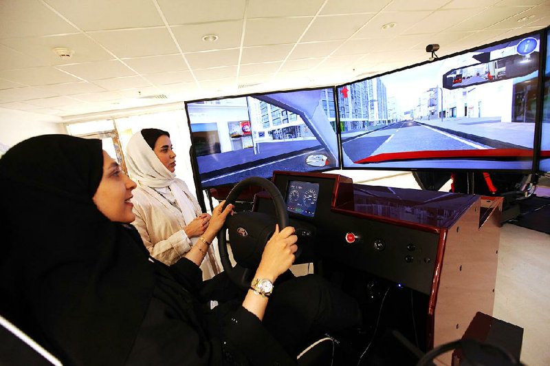 A woman tests her skills earlier this week in a simulator at a driving school in Dhahran, Saudi Arabia. The Saudi ban on female drivers ends Sunday. Bloomberg News/MOHAMMED AL-NEMER   

