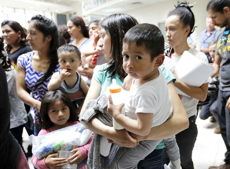 Women and children wait inside a bus station Friday after they were processed and released by U.S. Customs and Border Protection in McAllen, Texas.  