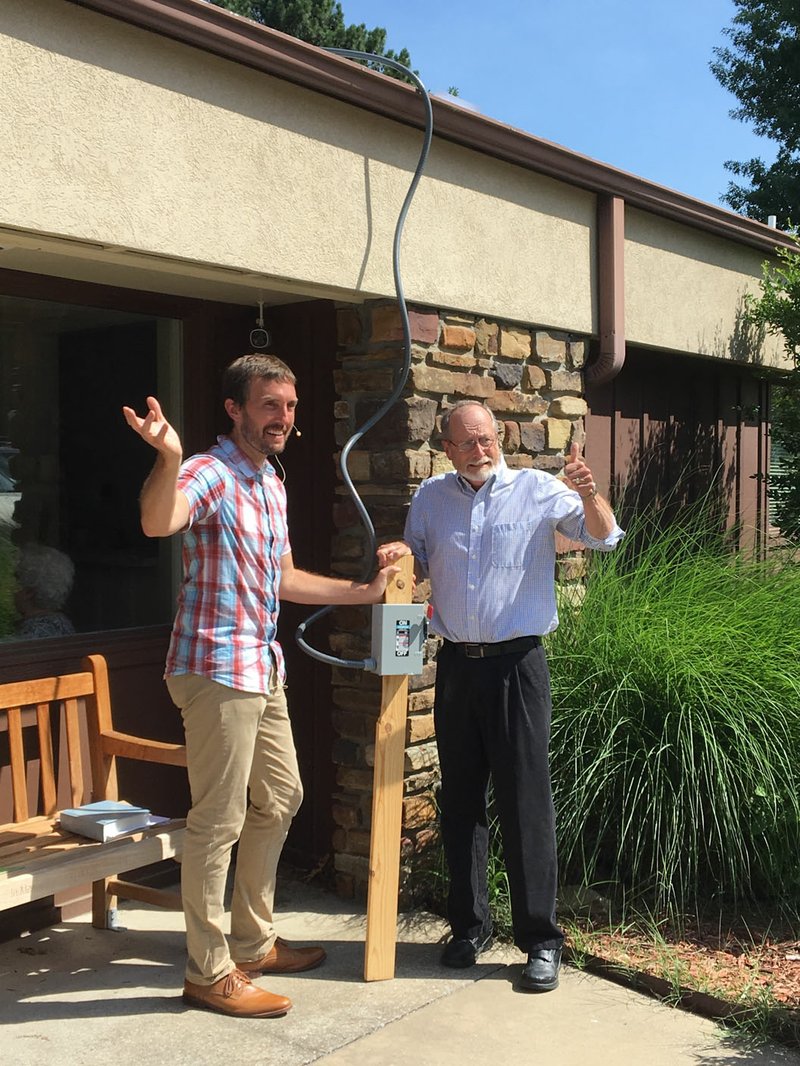Courtesy Photo Pastor Clint Schnekloth (left) and Fayetteville Mayor Lioneld Jordan celebrate the fact that Good Shepherd Lutheran Church in Fayetteville has been banking energy since its solar array went online in May.