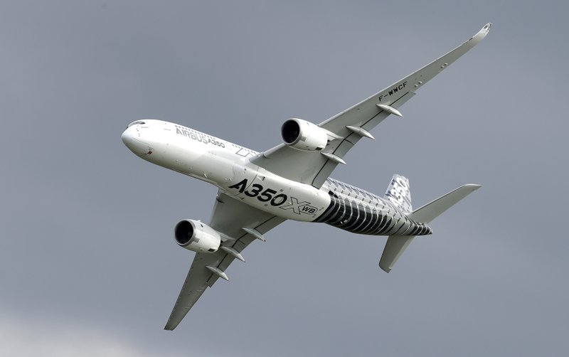 FILE - In this Wednesday, April 25, 2018 file photo, an Airbus A350 flies during the ILA Berlin Air Show in Berlin, Germany. Aviation giant Airbus has threatened to leave Britain if the country leaves the European Union without an agreement on future trading relations. (AP Photo/Michael Sohn, File)