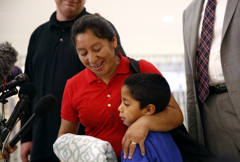 Beata Mariana de Jesus Mejia-Mejia, left, embraces her son Darwin Micheal Mejia as she speaks at a news conference following their reunion at Baltimore-Washington International Thurgood Marshall Airport, Friday, June 22, 2018, in Linthicum, Md. The Justice Department agreed to release Mejia-Mejia's son after she sued the U.S. government in order to be reunited following their separation at the U.S. border. She has filed for political asylum in the U.S. following a trek from Guatemala. (AP Photo/Patrick Semansky)