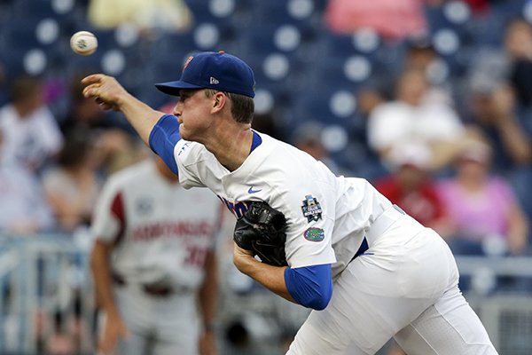 Florida pitcher Brady Singer throws against Arkansas in the first inning of an NCAA College World Series baseball game in Omaha, Neb., Friday, June 22, 2018. (AP Photo/Nati Harnik)