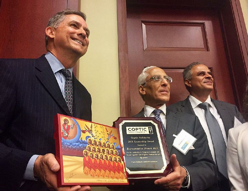 U.S. Rep. French Hill (left) poses Thursday with the icon and plaque he received from Coptic Solidarity President George Gurguis (center) and other Coptic Solidarity members. 