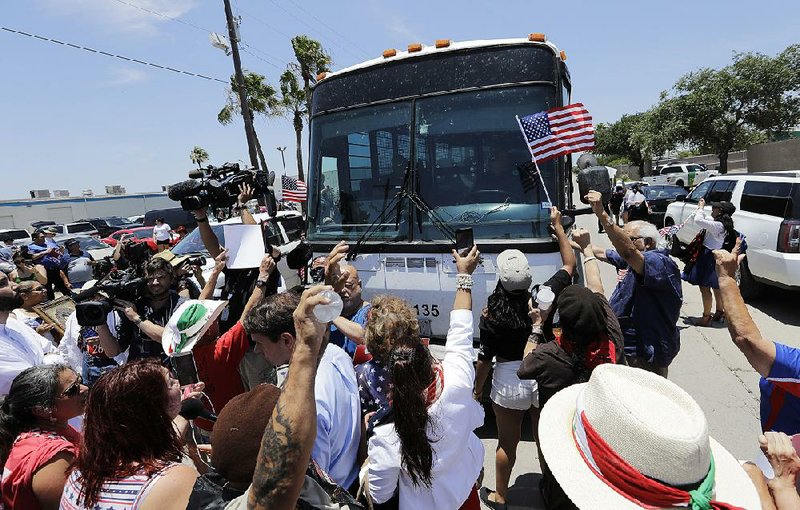 Demonstrators, shouting “Shame, Shame!” at Border Patrol agents, attempt to block a bus carrying detainees Saturday outside a U.S. Border Patrol processing center in McAllen, Texas.  